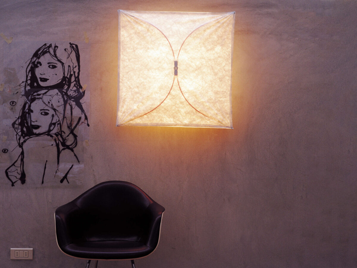 A contemporary Flos Ariette 1 light, showcasing its unique construction with a stretched textile diffuser and subtle internal metal supports that become visible when illuminated.