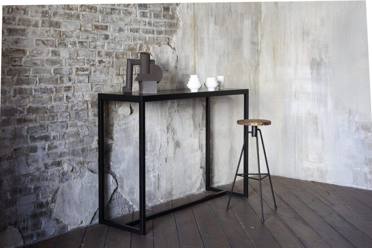 “Front view of NIKITA barstool with round seat and crossed steel legs, offering a sturdy yet elegant look for minimalist interiors.”