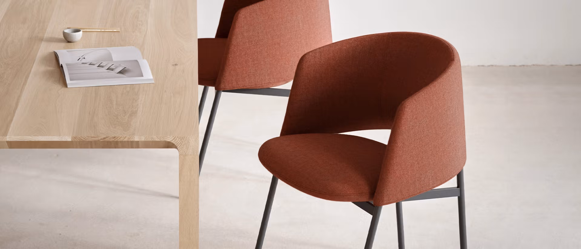 Modern dining chair with a sculptural curved backrest and sleek metal base.