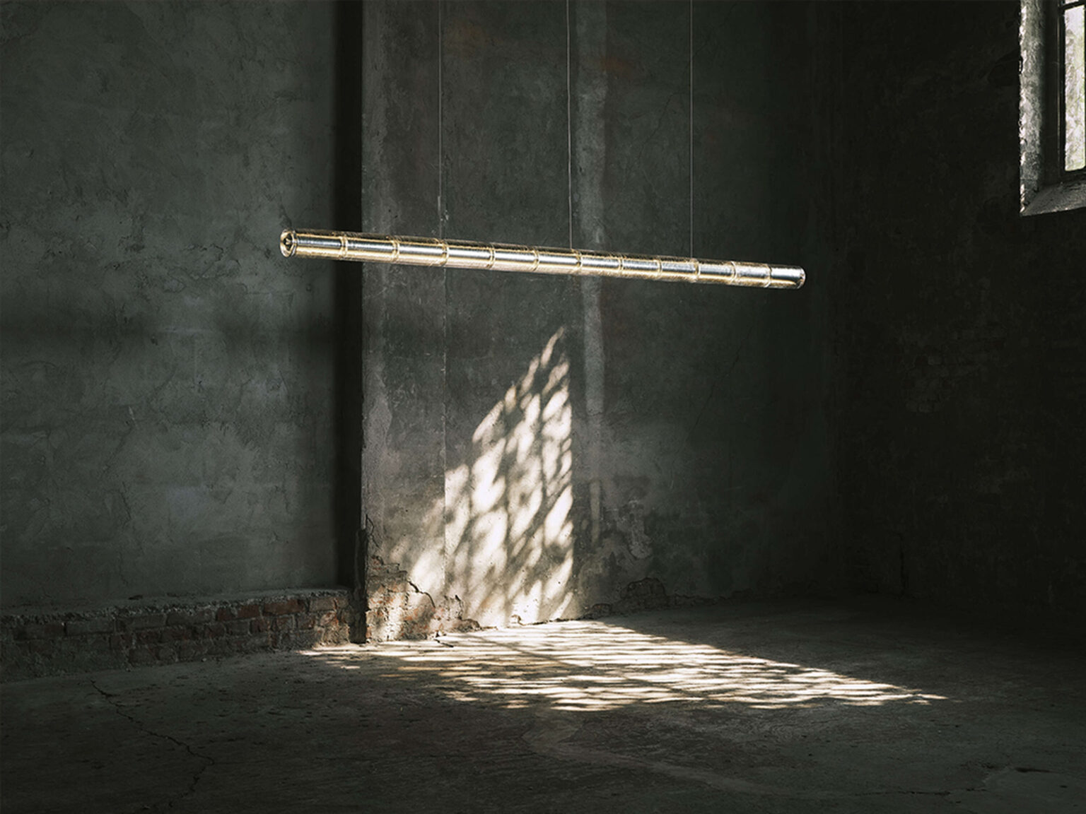 Close-up of one glass module in the Luce Orizzontale S1 showing thick artisanal cast glass with polished aluminum core and LED lighting.