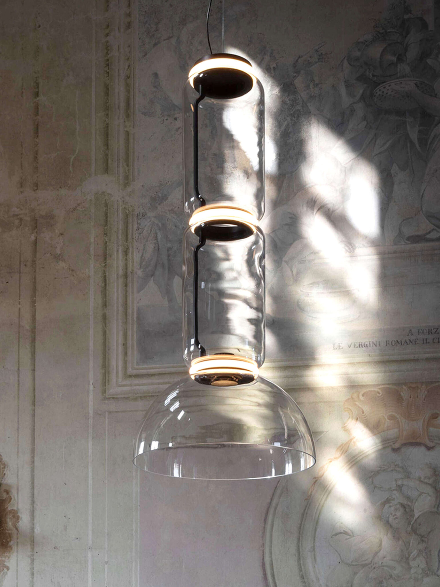 Side view of Noctambule S2 featuring two transparent glass cylinders above a crisp bowl shade, dripping from a ceiling cable.
