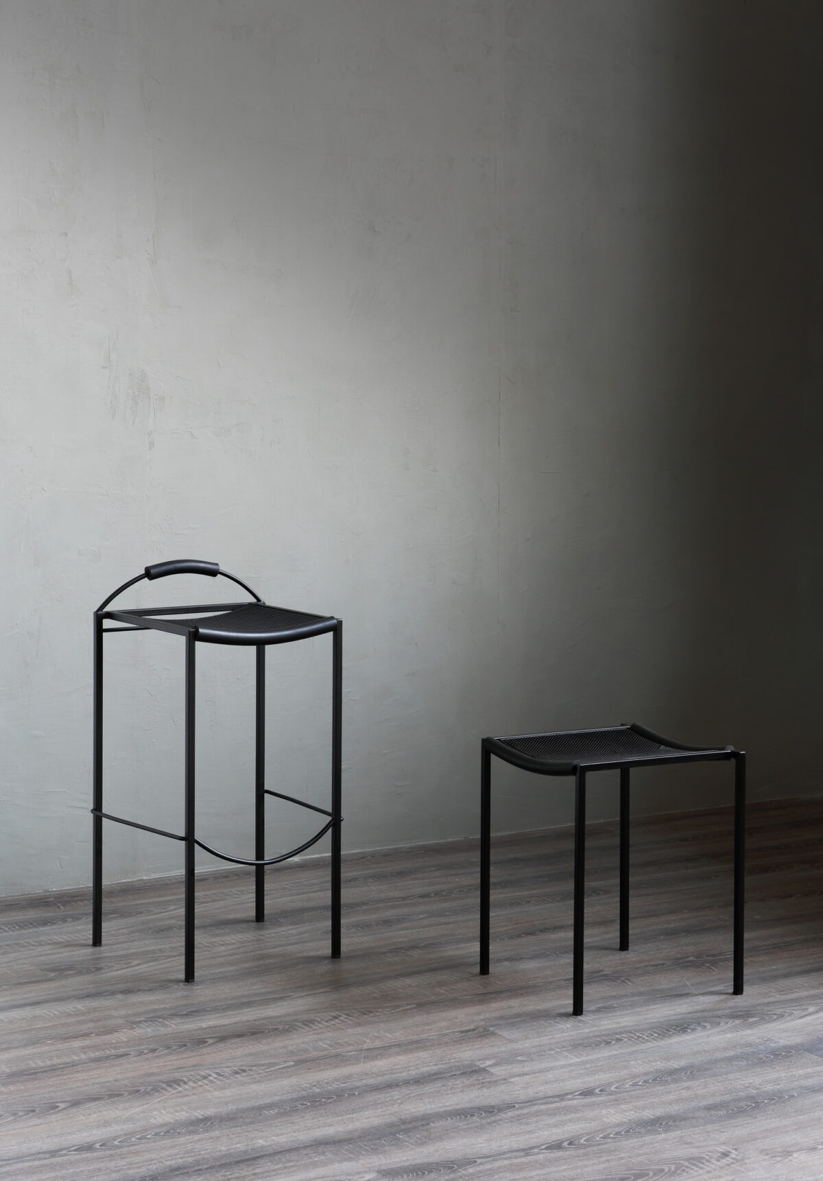 “Front-facing SGABELLO Basso with visible weld joints and embossed epoxy-painted frame, emphasizing industrial craftsmanship.”