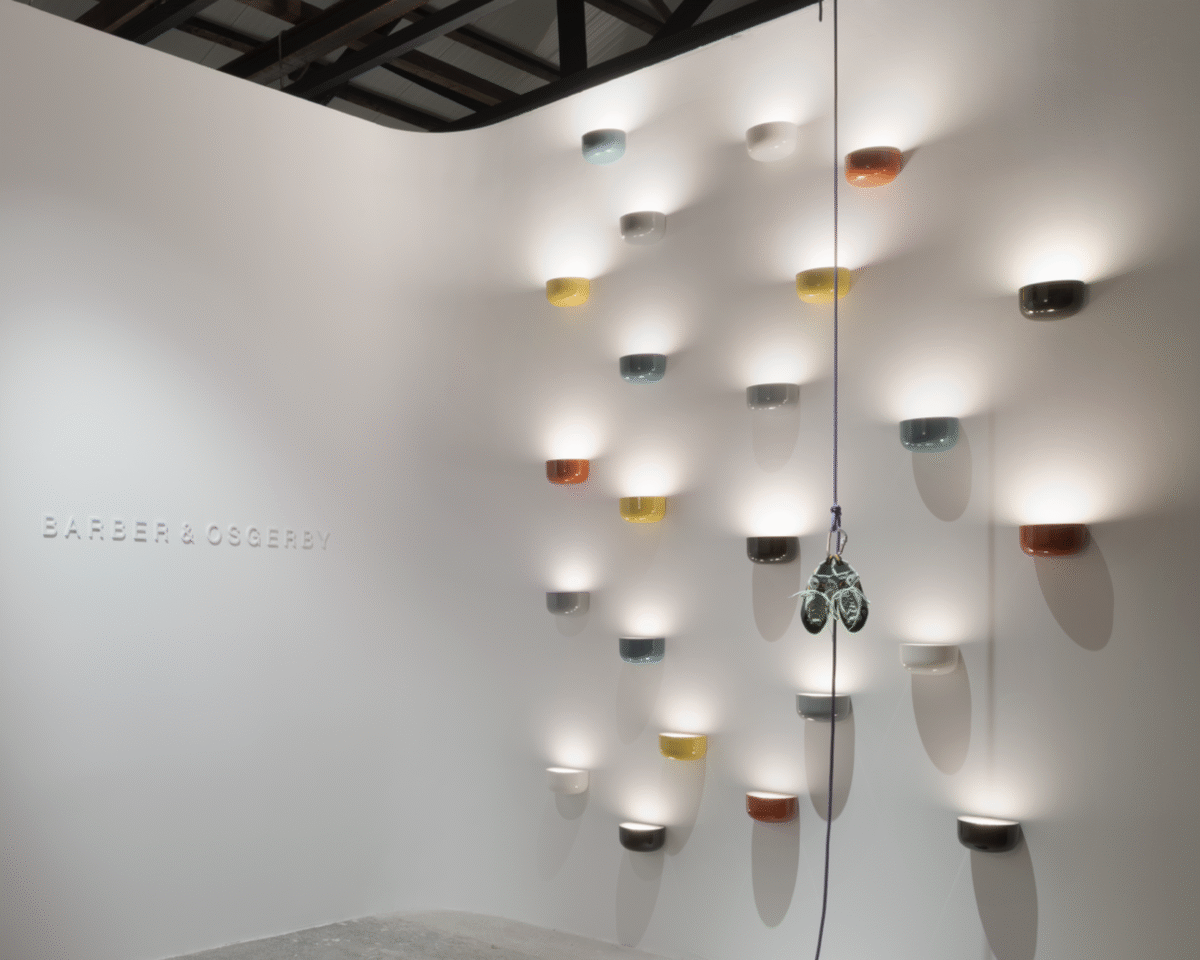 An architectural Flos Bellhop Wall Up lamp in [specific color, e.g., "grey blue" or "brick red"], designed for wall installation, with its unique inverted dome shape directing light beautifully.