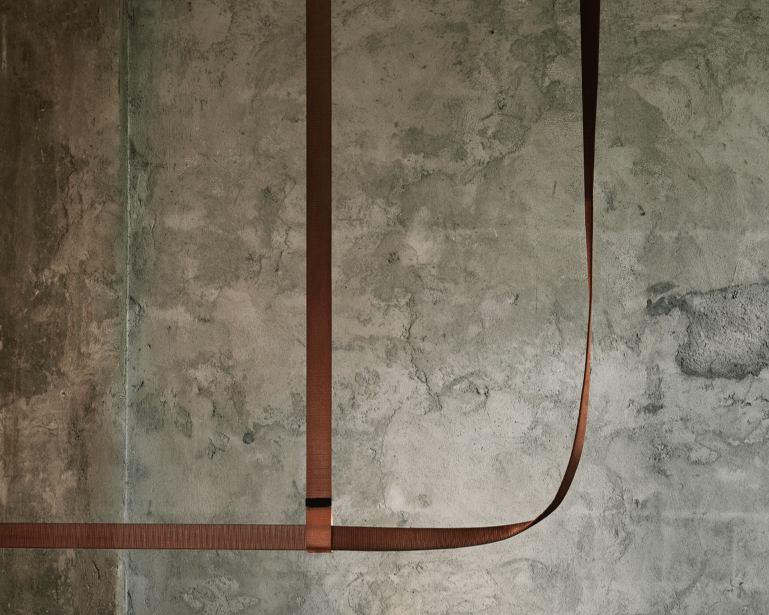 Close-up of copper‑brown fabric surface on the Belt pendant, showing aluminium channel beneath the textile.