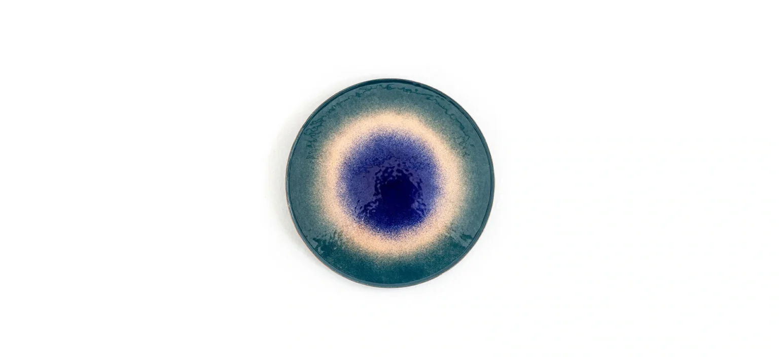 Fire Eater Small Table by Moroso close‐up of copper top’s layered vitreous powder finish showing rich, unpredictable color variations at the Michigan Design Center