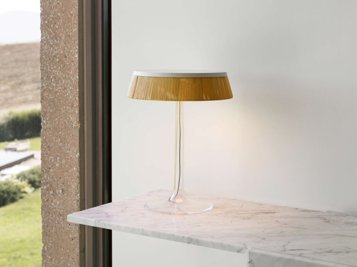 Bon Jour Table Lamp by Flos styled on a side table, highlighting its minimalist transparency and warm glow in Royal Oak Michigan