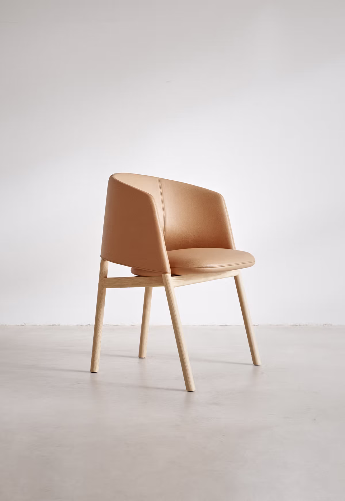 The Collar Dining Chair placed around a contemporary dining table, perfect for any stylish setting.