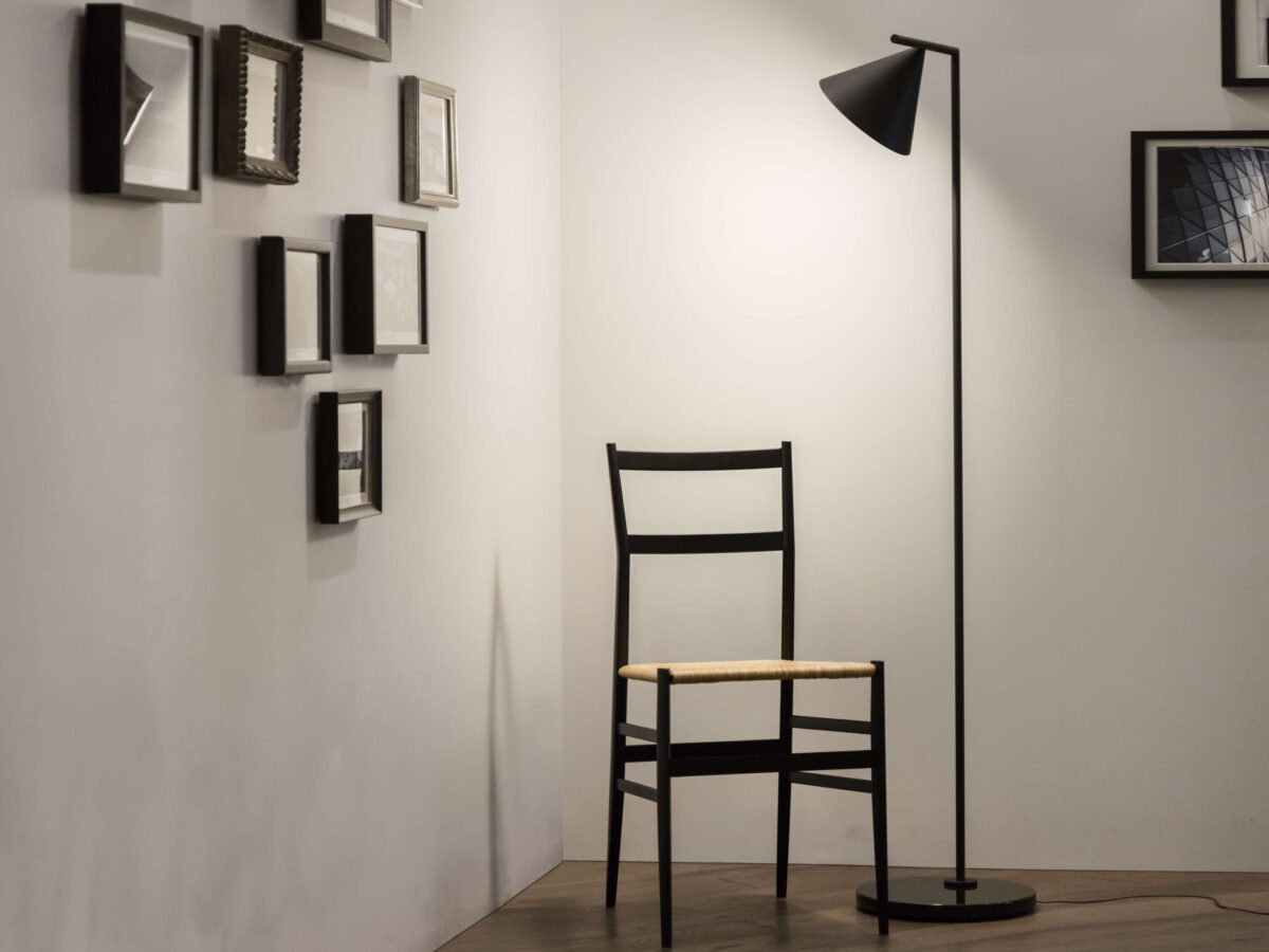 Matte black steel floor lamp featuring a rotating conical diffuser and heavy black Marquina marble base.