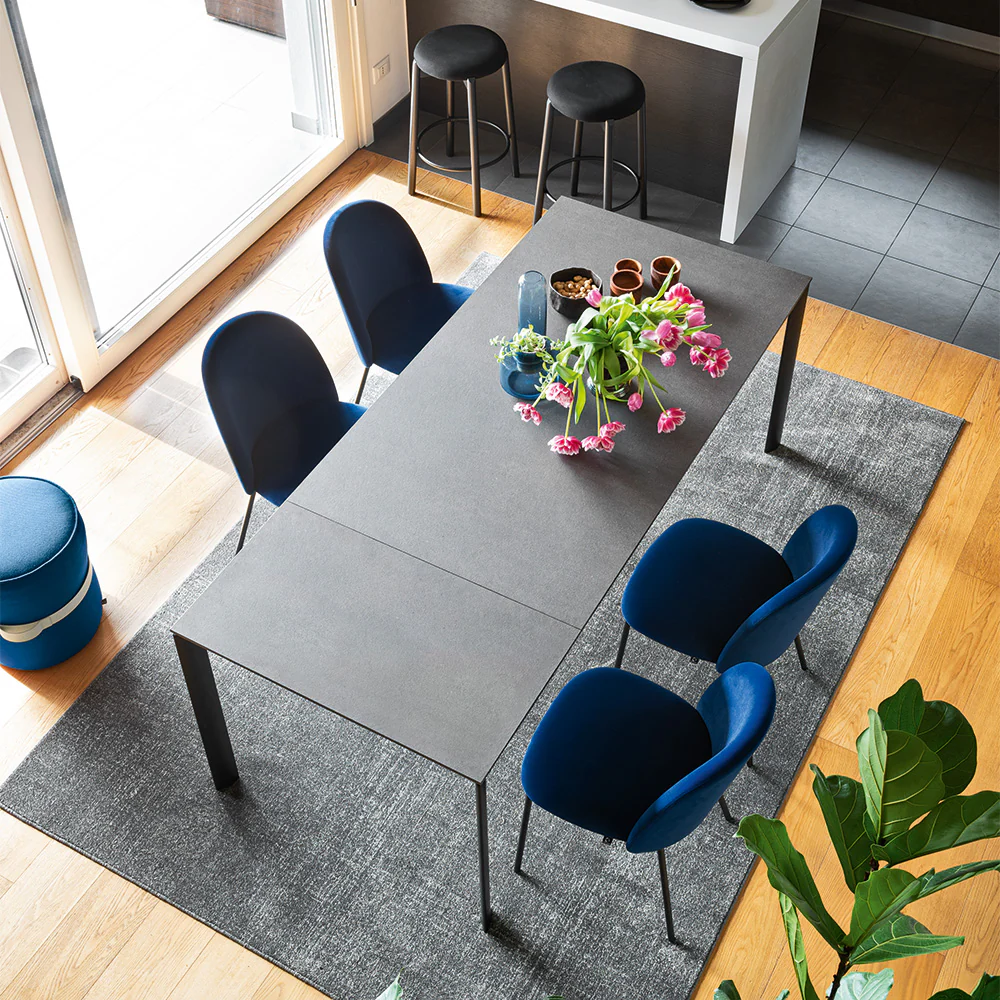 “EMINENCE EVO by Connubia in styled dining room – elegant extendable table with ceramic or wood finish options”