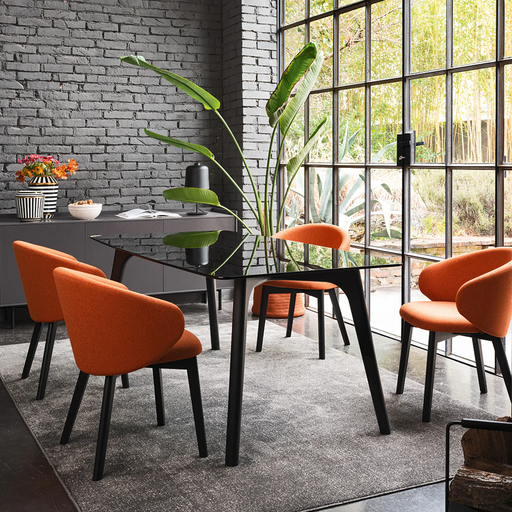“Side view of TUKA chair by Connubia – contemporary curved design with soft padding and sleek profile”