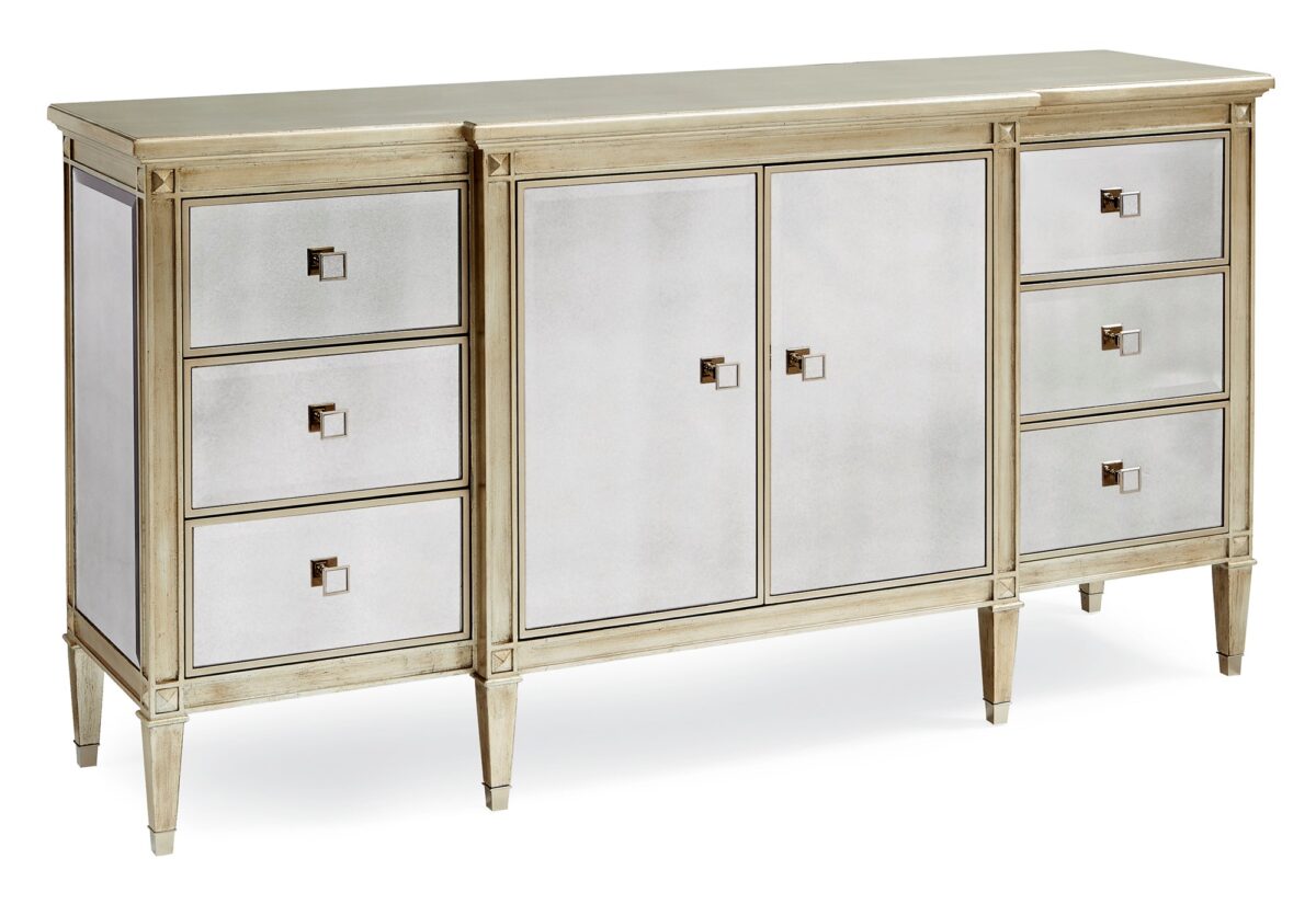 La‑Dee‑Dah Dresser by Caracole — a 74″‑wide carved dresser with six soft‑close side drawers and two mirrored center doors, finished in Auric silver leaf with beveled antique-mirror fronts, square tapered carved feet with metal ferrules, and a gold-painted interior featuring a tray drawer and shelf.
