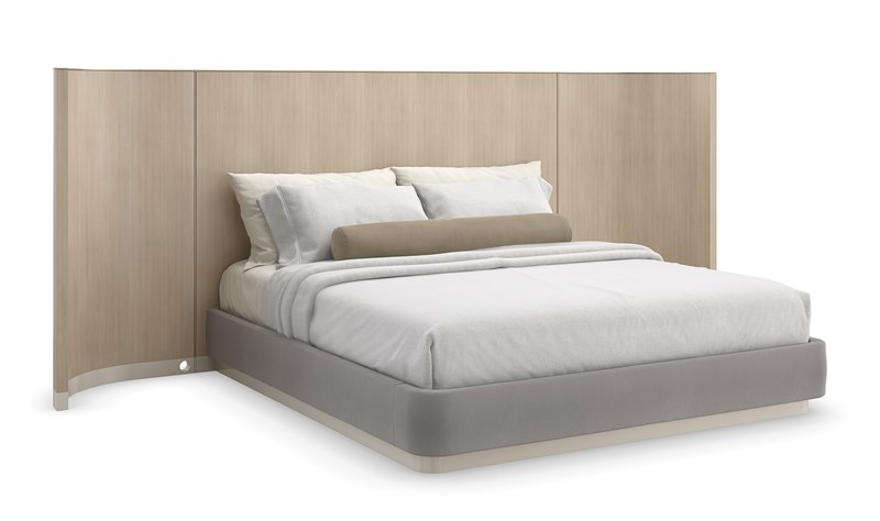 Caracole Dream Chaser King Bed with Panels featuring a parsons-shaped headboard crafted from Koto veneers finished in Dry Martini, encased in Brushed Gold metal trim, with wood-paneled wings and upholstered side rails and footboard in pale gray mohair fabric, set on a Cloud-finished wood plinth base.