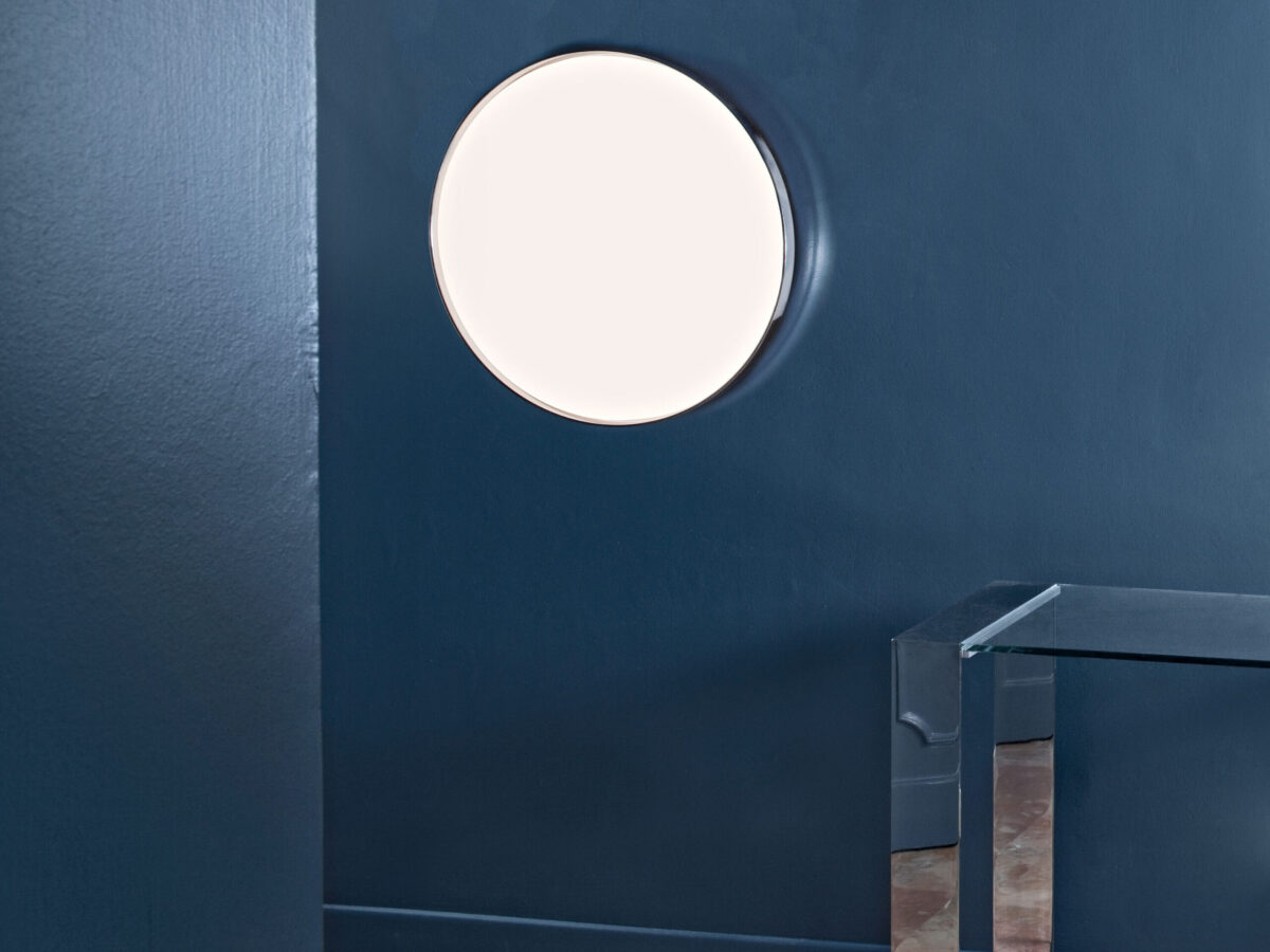 A Flos Clara ceiling/wall light with a clean, minimalist design, emphasizing its broad, uniform glow from the high-efficiency opal polycarbonate diffuser.