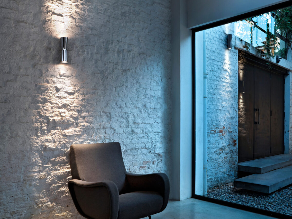 Minimalist and robust, the Flos Clessidra 20°+20° wall light in [specify color, e.g., "chrome" or "deep brown"], known for its dual-beam illumination and suitability for both indoor and outdoor wet locations (IP55).