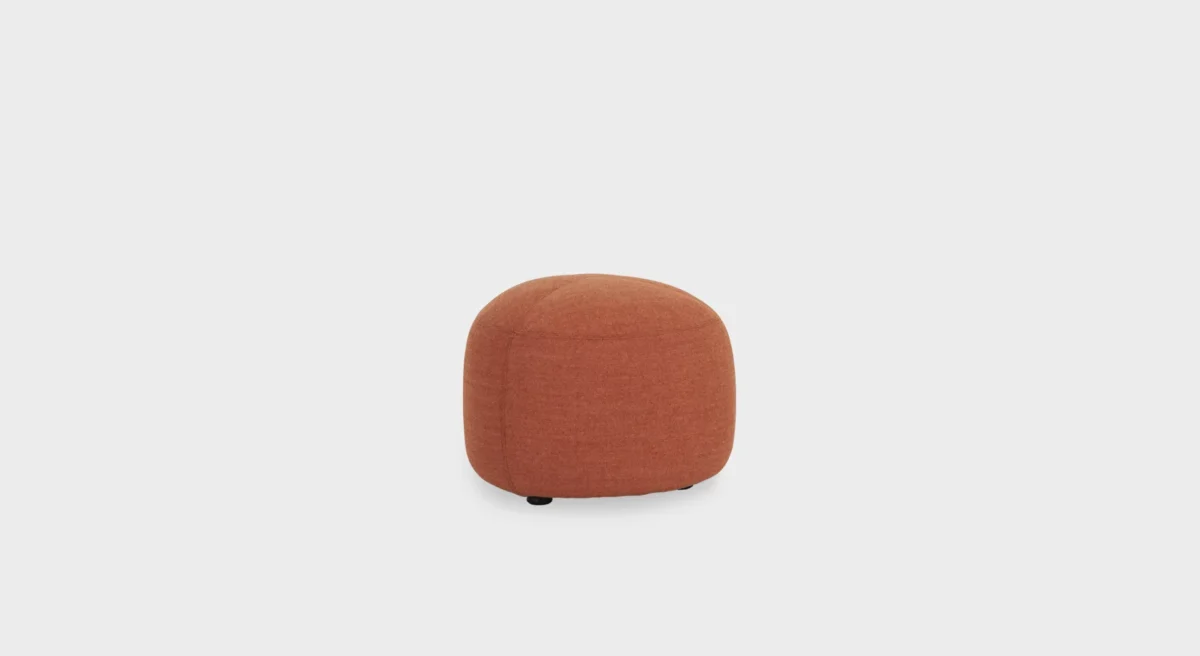 “Low-profile KIPU D01 pouf featuring a rounded triangular form and upholstered top for comfort.”