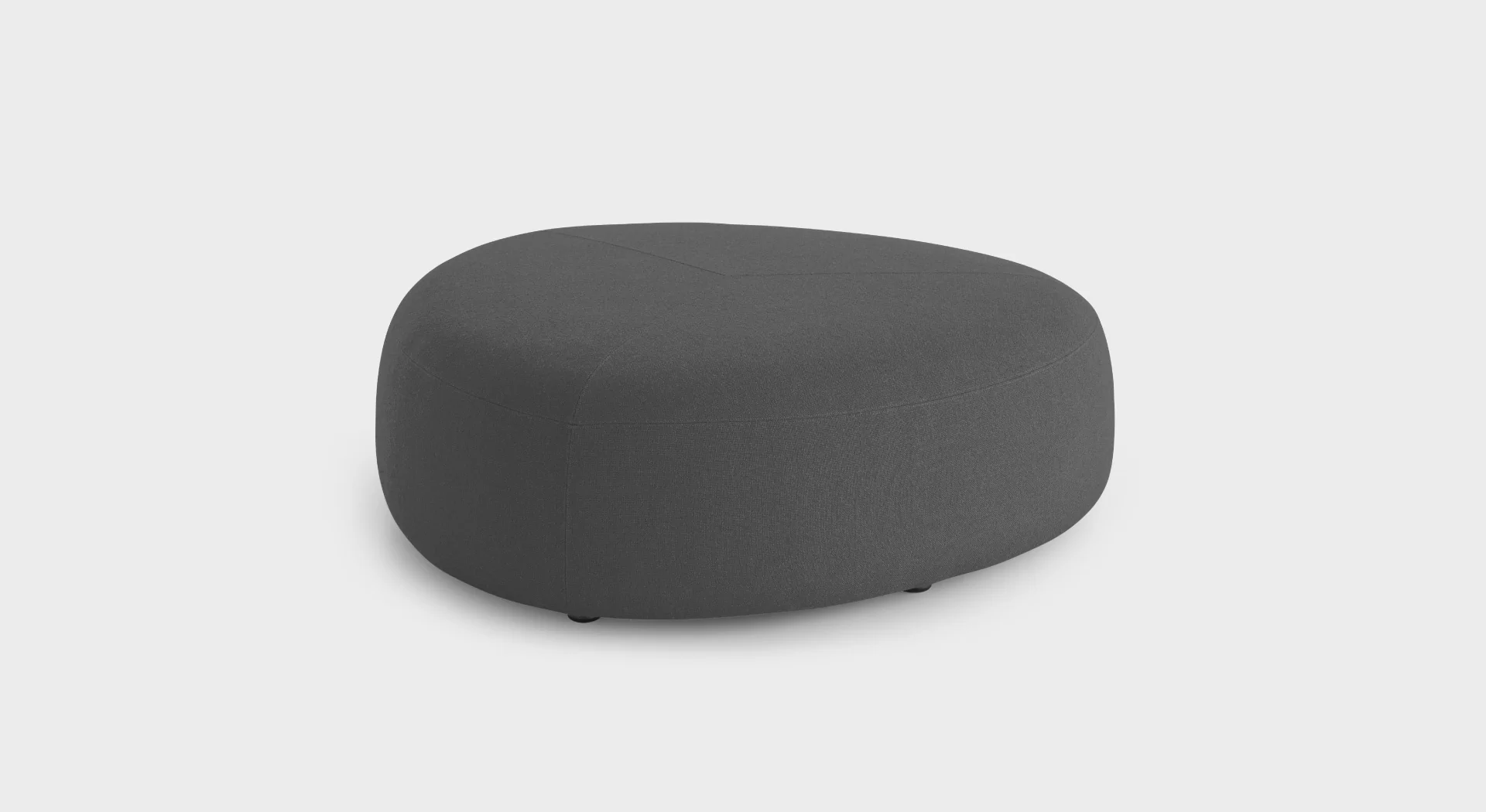 “Lapalma Kipu D05 pouf with rounded triangular shape, upholstered in soft grey fabric, positioned in a modern lounge area.”