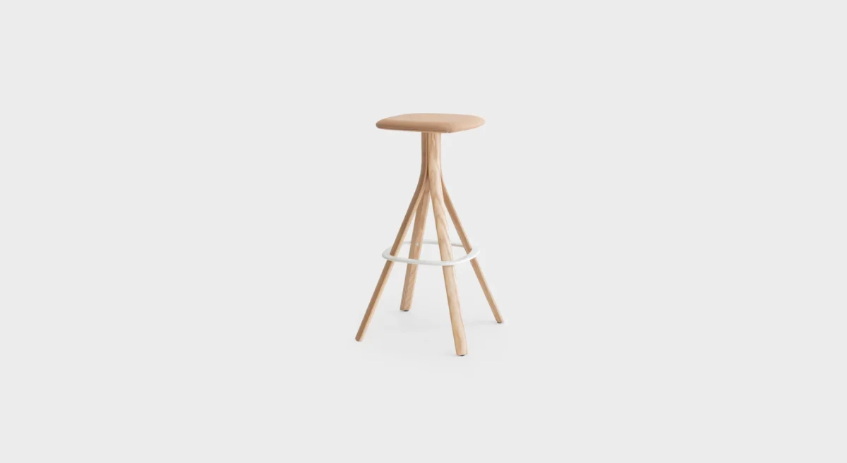 Lusto S461 four-legged stool by Lapalma, designed by Karri Monni, featuring a solid ash wood frame in natural or black finish, powder-coated steel footrest, and a painted or fully upholstered seat in fabric, leather, or eco-leather.
