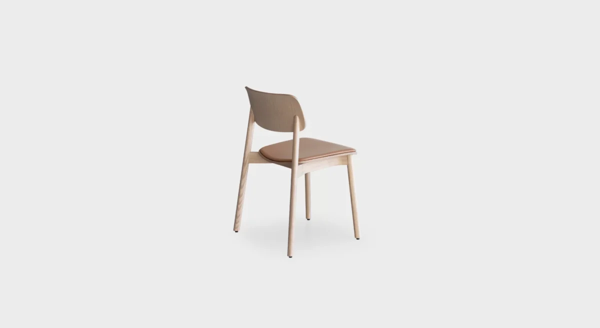 Lapalma Oiva S371 stackable wooden chair with solid ash frame, curved plywood backrest, and upholstered seat pad in fabric or leather.