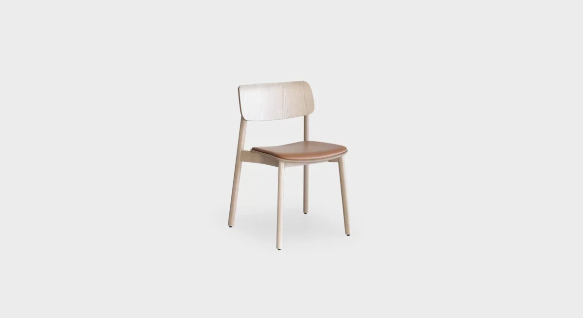 Lapalma Oiva S371 stackable wooden chair with solid ash frame, curved plywood backrest, and upholstered seat pad in fabric or leather.