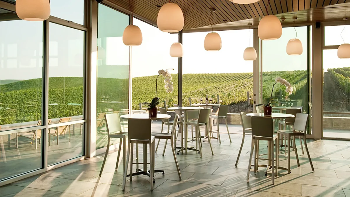 The Hudson Stool with Arms by Emeco, featuring a sleek design and durable construction.
