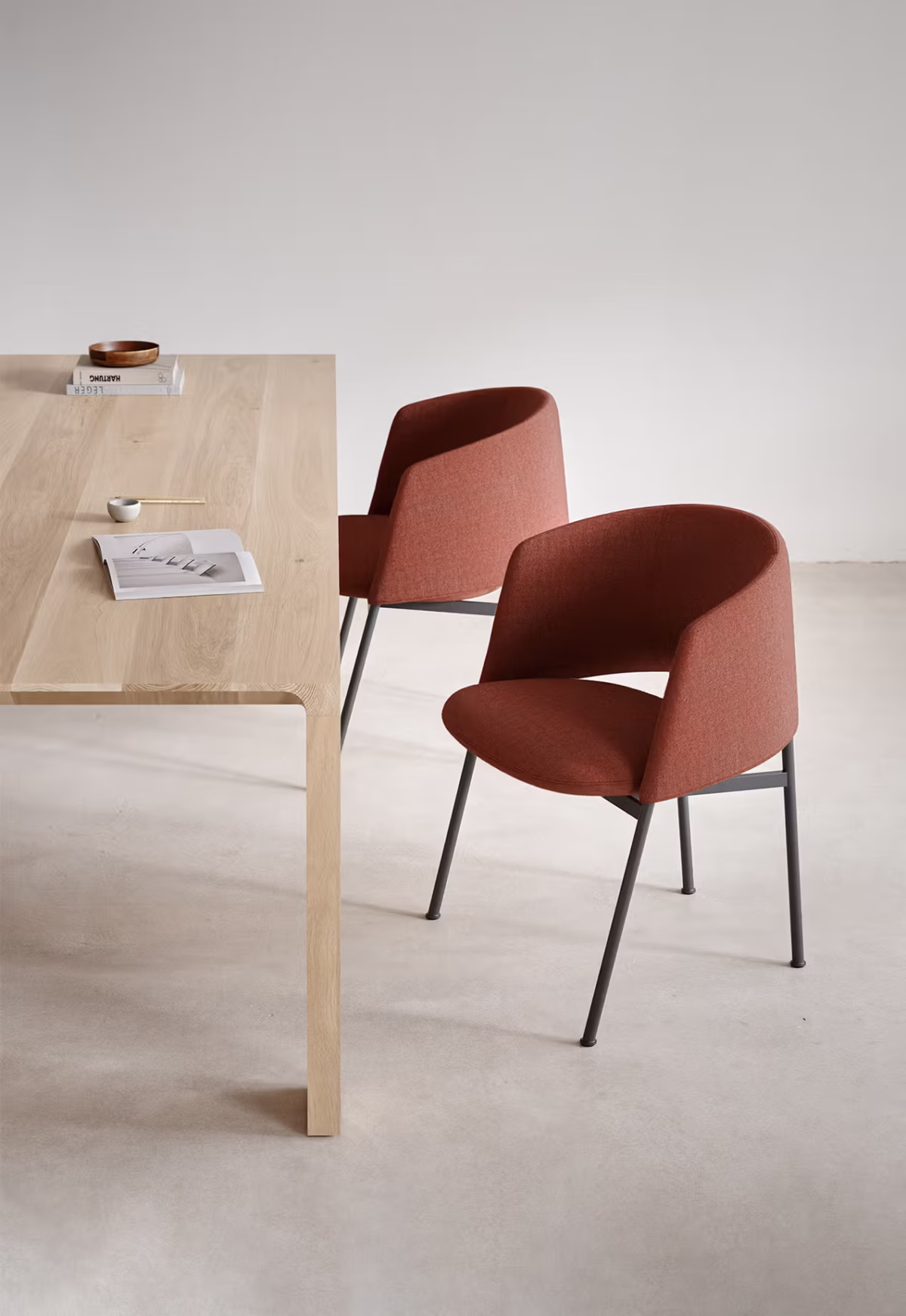 The Collar Dining Chair featuring a polished chrome base, adding a contemporary touch to the design.