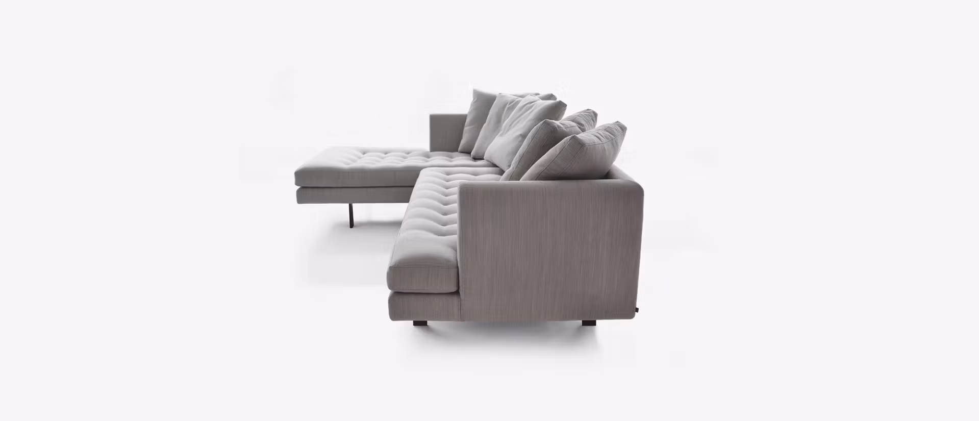 Modern sectional sofa featuring a sleek silhouette with button-tufted cushions and down-filled backrests.