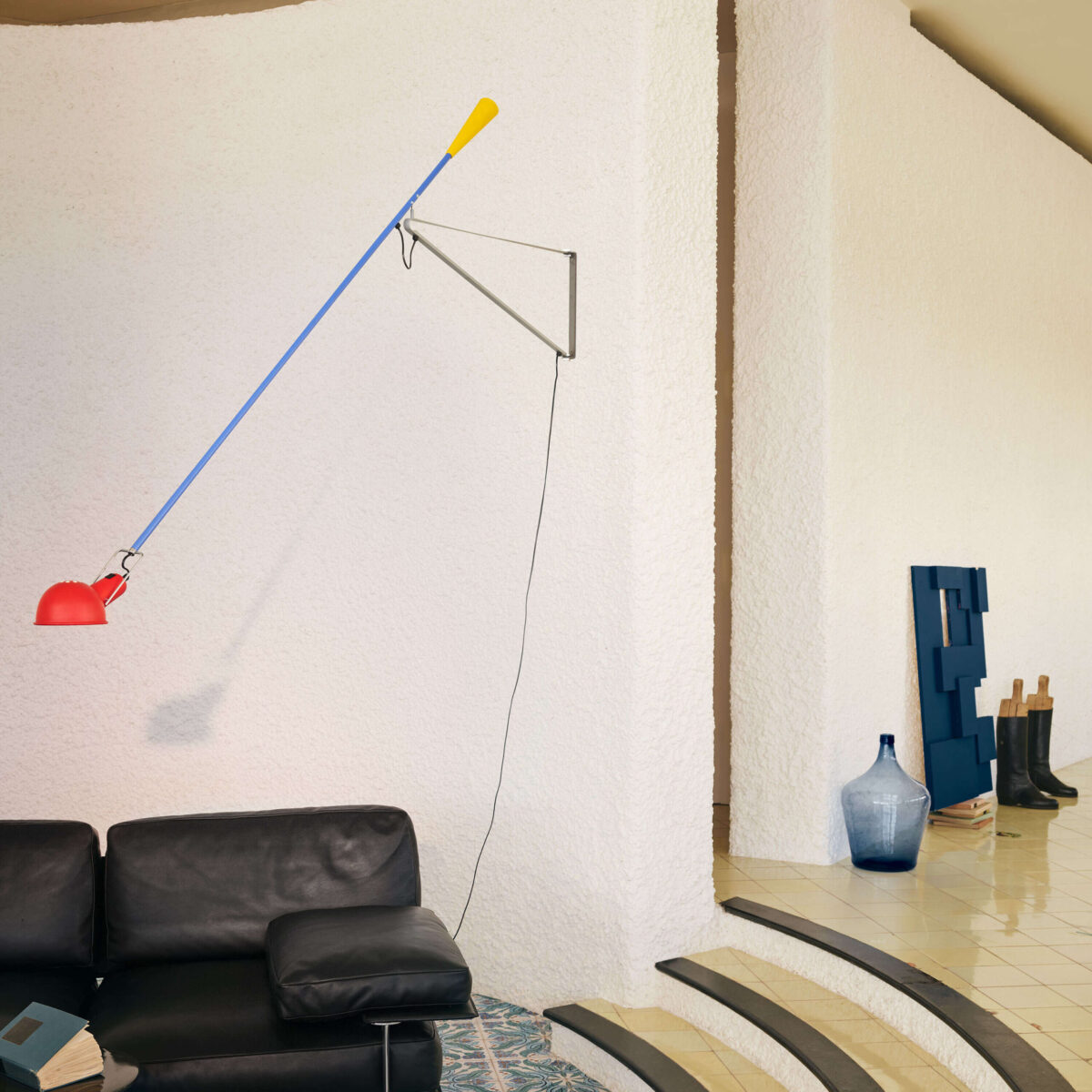 Modern and colorful Flos 265 Chromatica wall lamp with a lengthy blue steel arm, a vibrant red shade, and a yellow cast-iron counterweight, designed to illuminate various spaces.