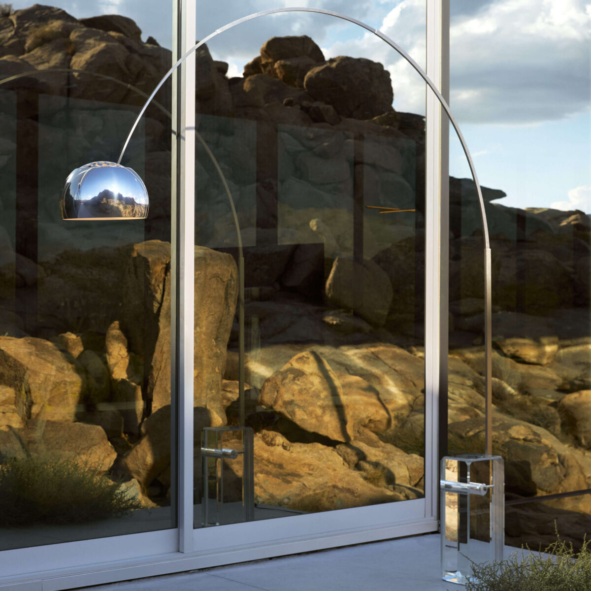 Designer floor-to-ceiling lamp: crystal base with internal mechanics exposed, stainless-steel arch, and height‑adjustable shade.