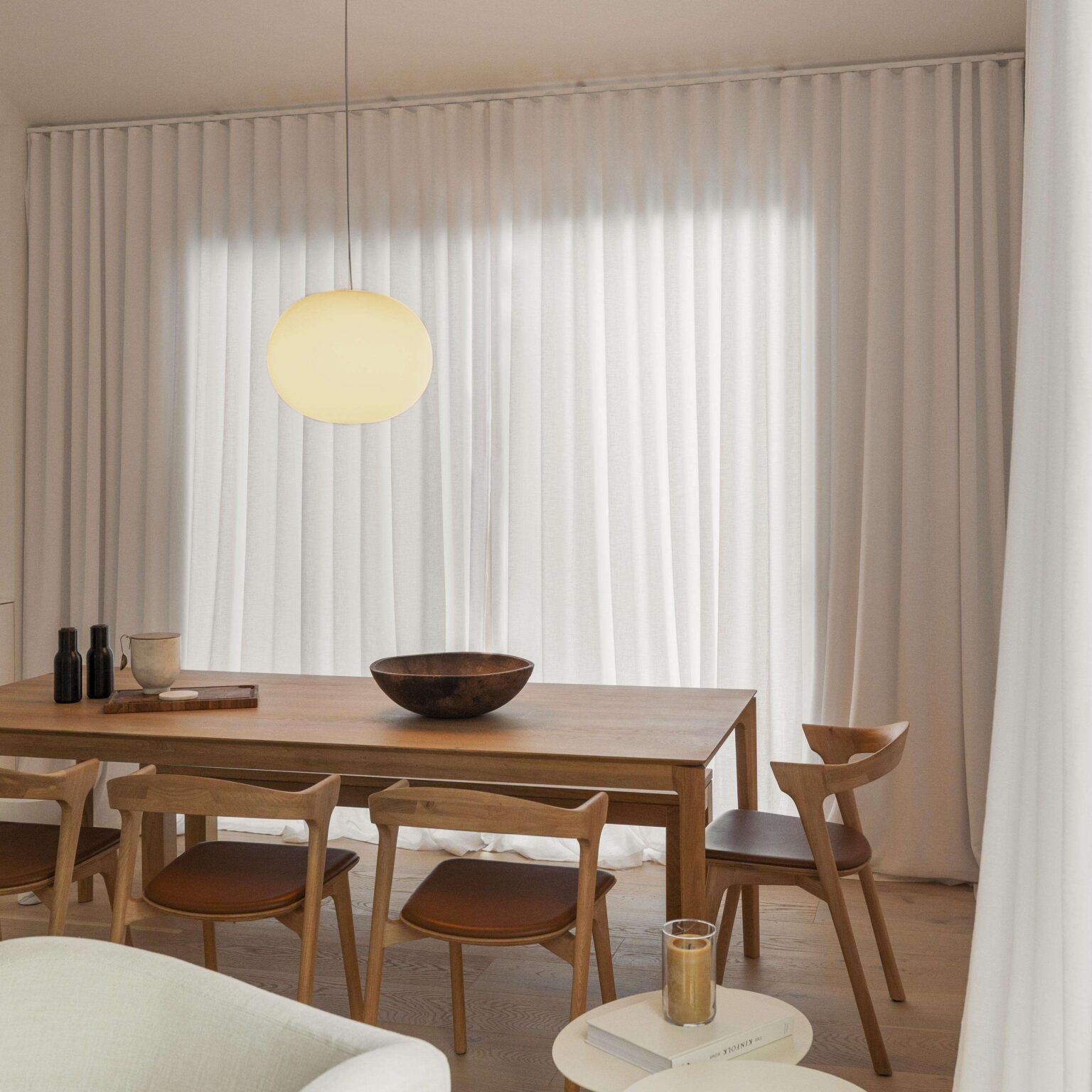 Large Glo‑Ball S2 hanging over a dining table, its diffused white light casting ambient warmth into the space.