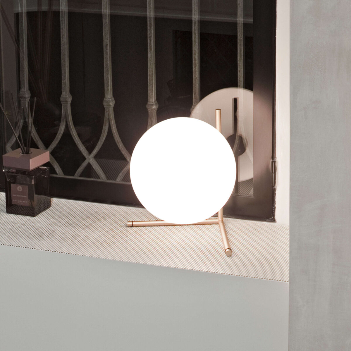 Modern table lamp with a blown glass sphere delicately poised on a horizontal stem, IC Lights T2 by Flos.
