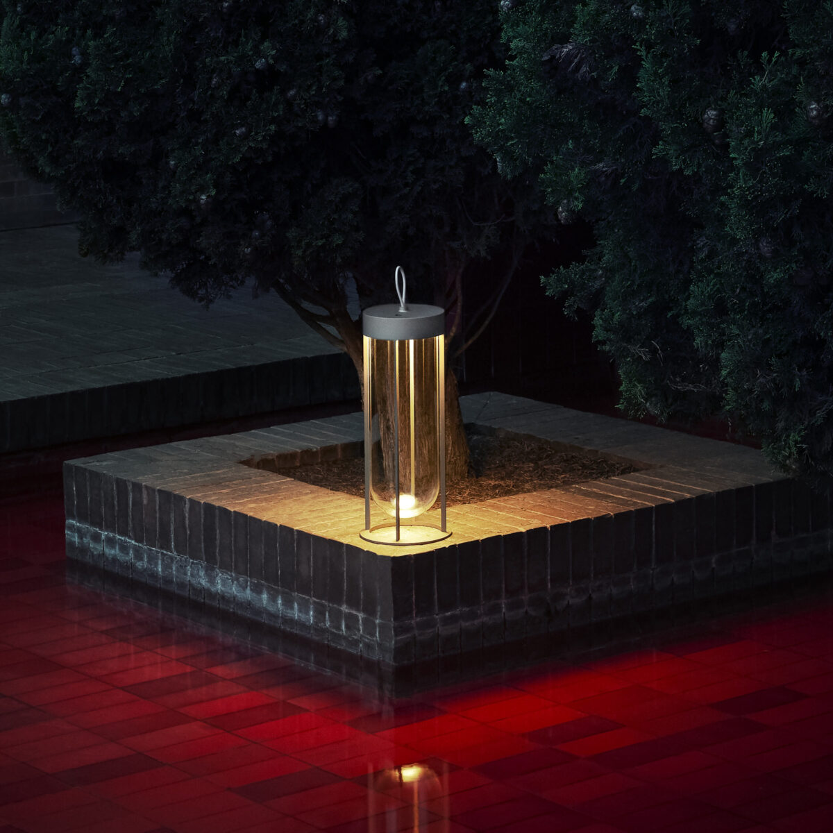 Modern outdoor lantern with rechargeable LED light and slim open frame, In Vitro Unplugged by Flos in deep green.