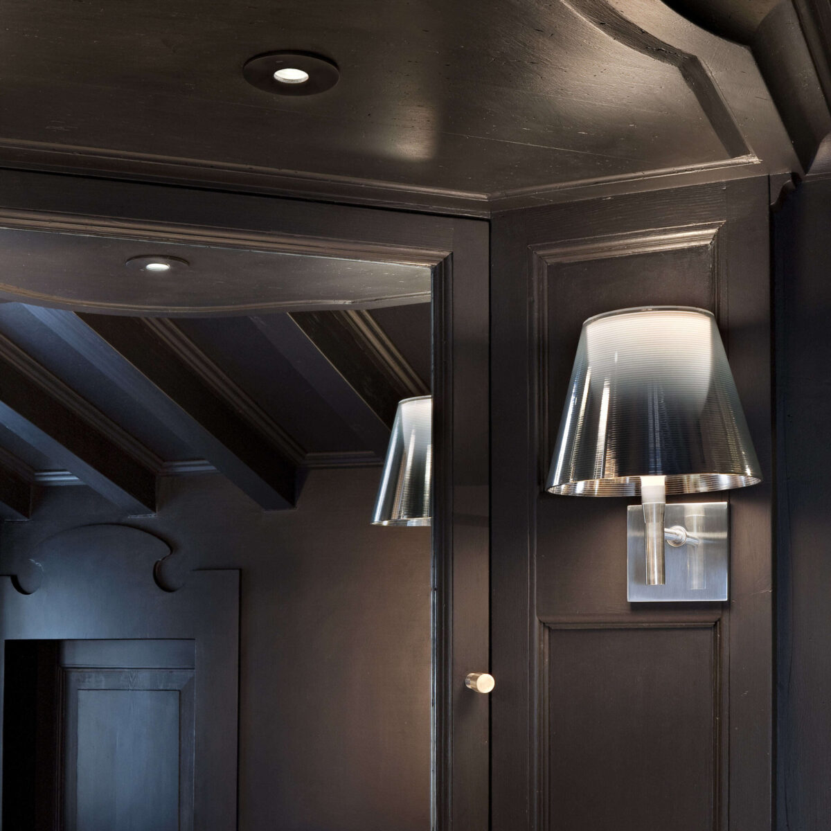 The iconic Flos KTribe Wall by Philippe Starck, an elegant wall-mounted fixture with a contemporary design, characterized by its layered diffuser system for glare-free illumination.
