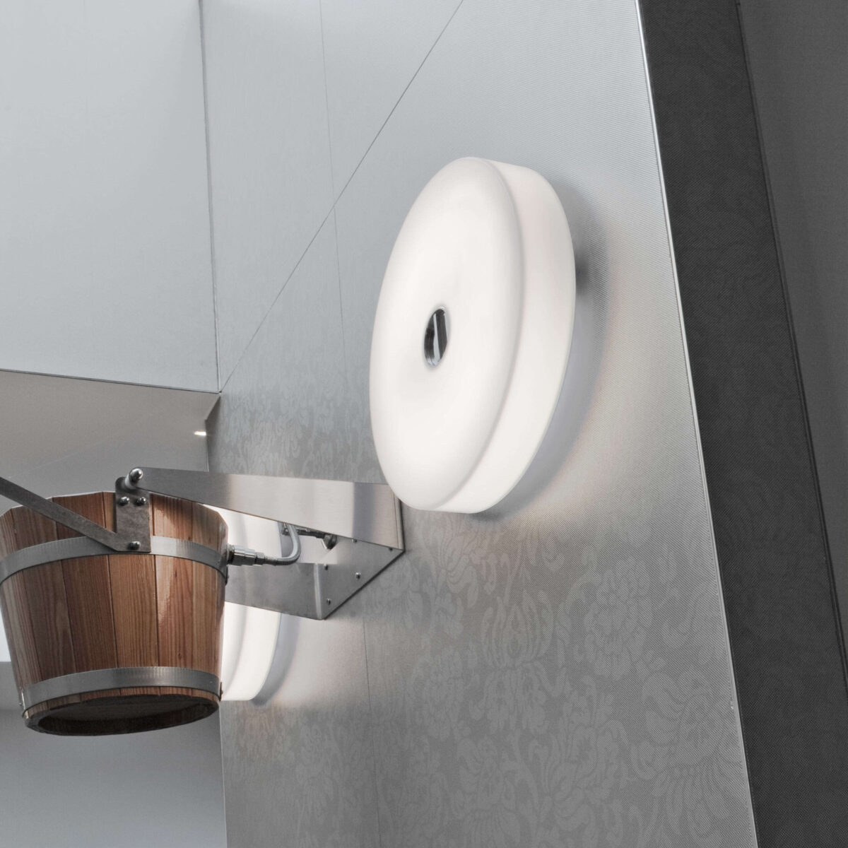 The minimalist Flos Mini Button by Piero Lissoni, a compact circular wall/ceiling fixture designed for both indoor and outdoor use, with a silicone elastomer seal for durability.