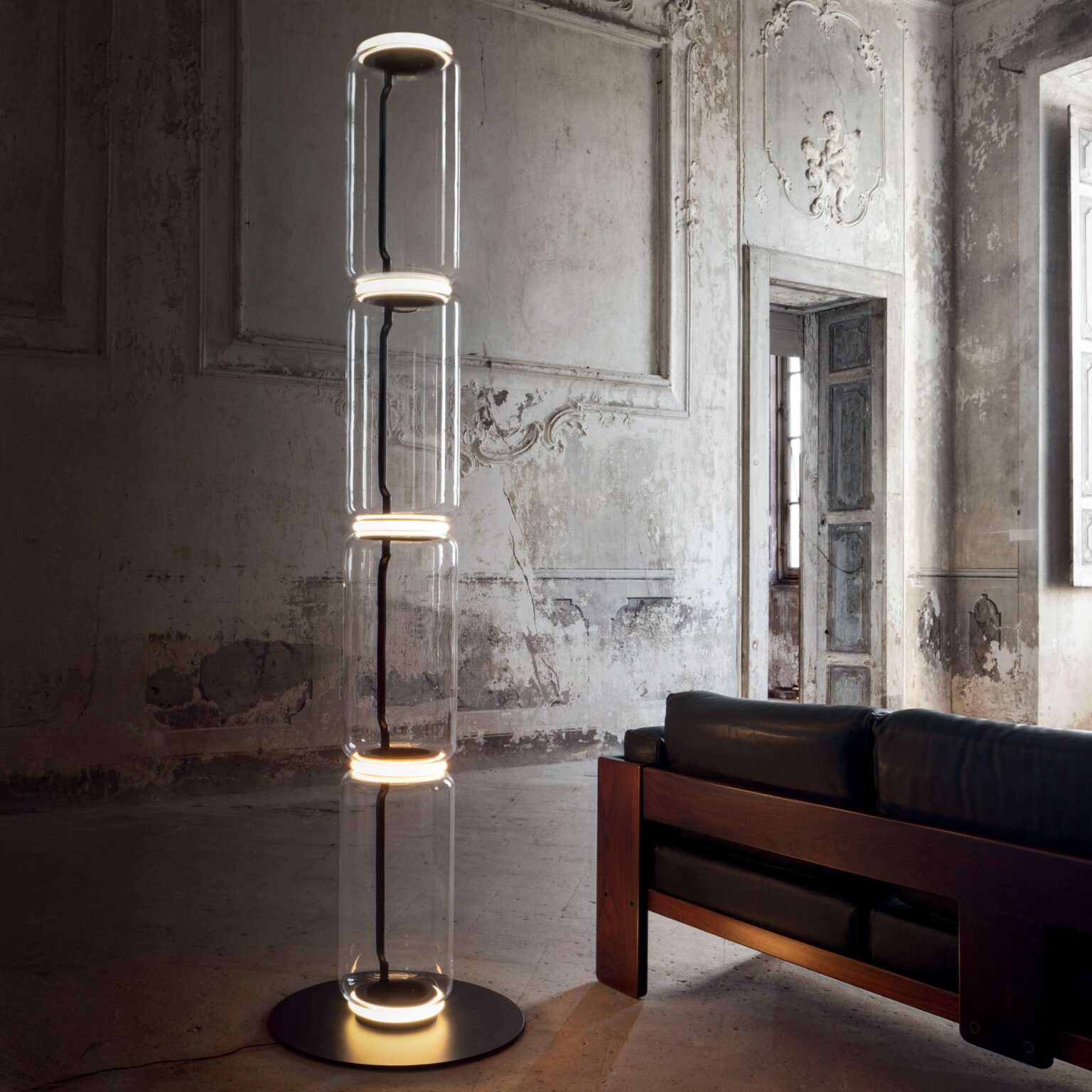 Minimalist lighting totem: four clear glass modules with soft LED rings between each, standing 217 cm tall.