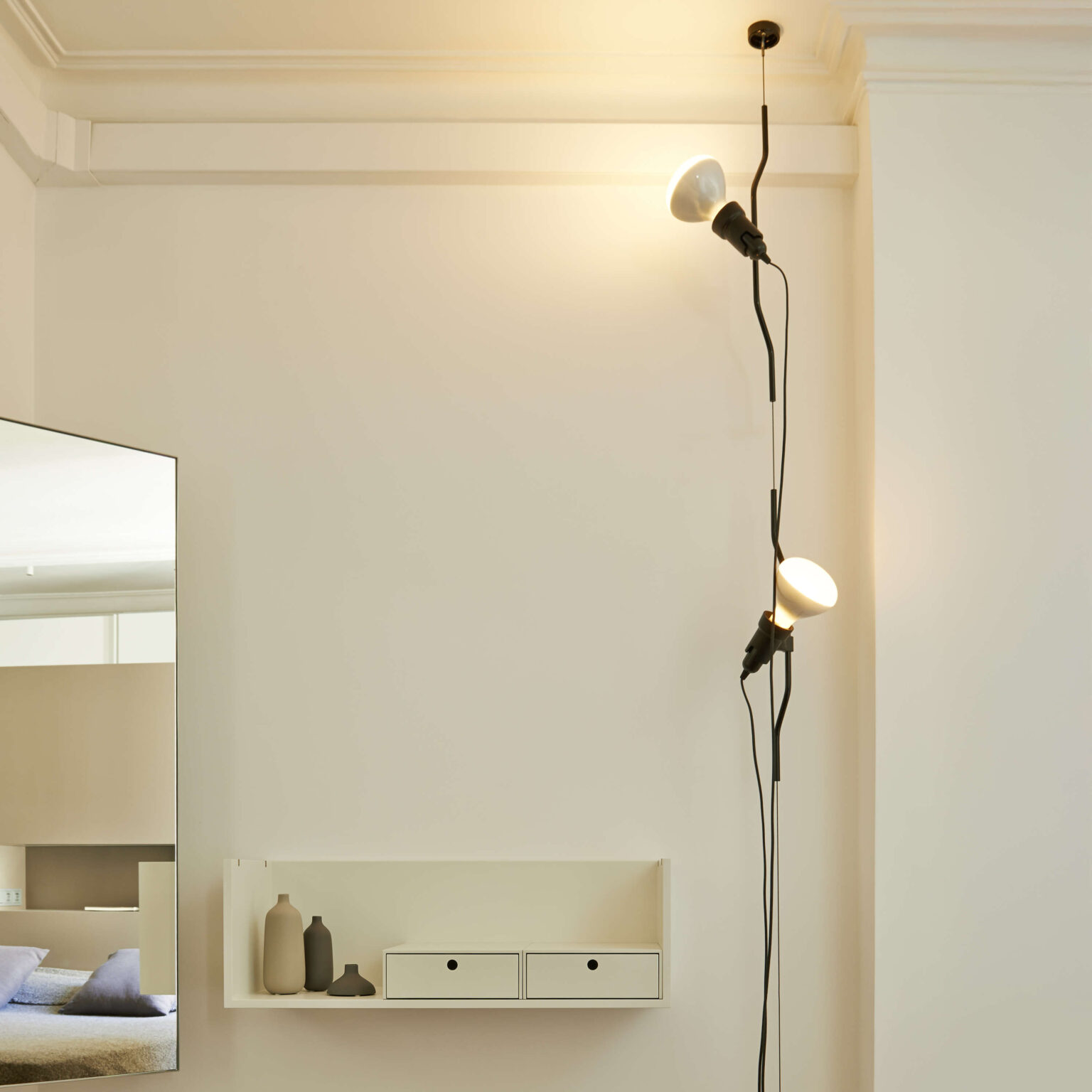 Close-up of the Parentesi lamp’s injection-molded black elastomer head, with an adjustable bulb sleeve on a taut steel cable.