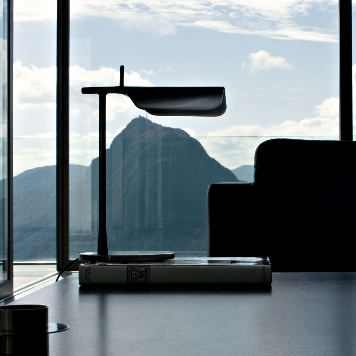 Close-up of the Tab Table lamp by Flos, showcasing its angular LED head and matte finish.