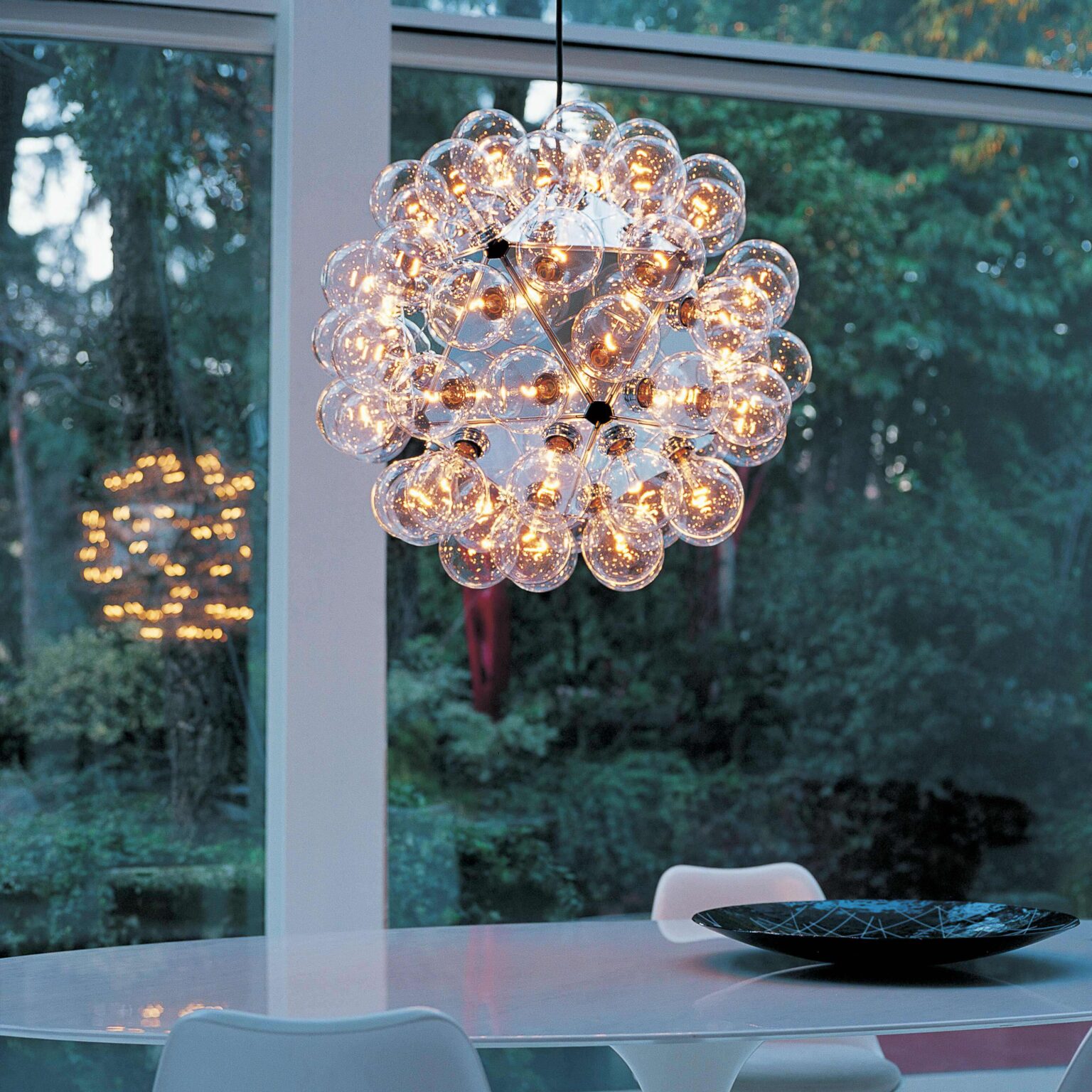 Close-up of Taraxacum 88’s alloy triangular frame and clustered clear glass bulbs, reflecting light in all directions.