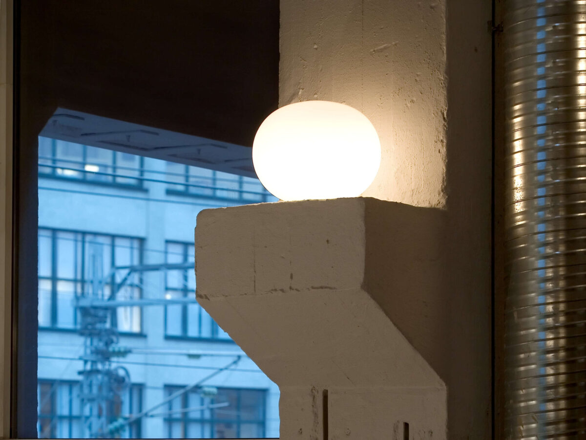 Glo‑Ball Basic 1 Table Lamp by Flos side profile highlighting 30% fiberglass‑reinforced polyamide base and glowing milky globe in a Troy Michigan setting