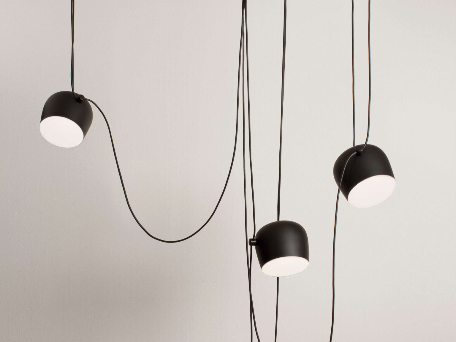 Close‑up of the Aim lamp’s photo‑etched polycarbonate diffuser within the turned aluminum shade, glowing softly when lit.
