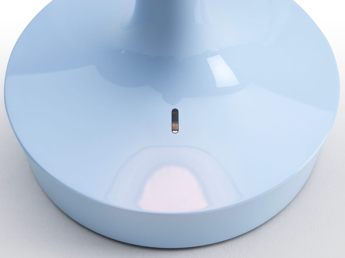 Compact and rechargeable lamp designed by Philippe Starck, Bon Jour Unplugged by Flos on a nightstand.