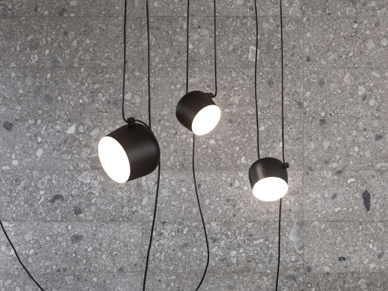 Close detail of the Aim lamp's smooth aluminum exterior and integrated swivel joint allowing adjustable aiming.