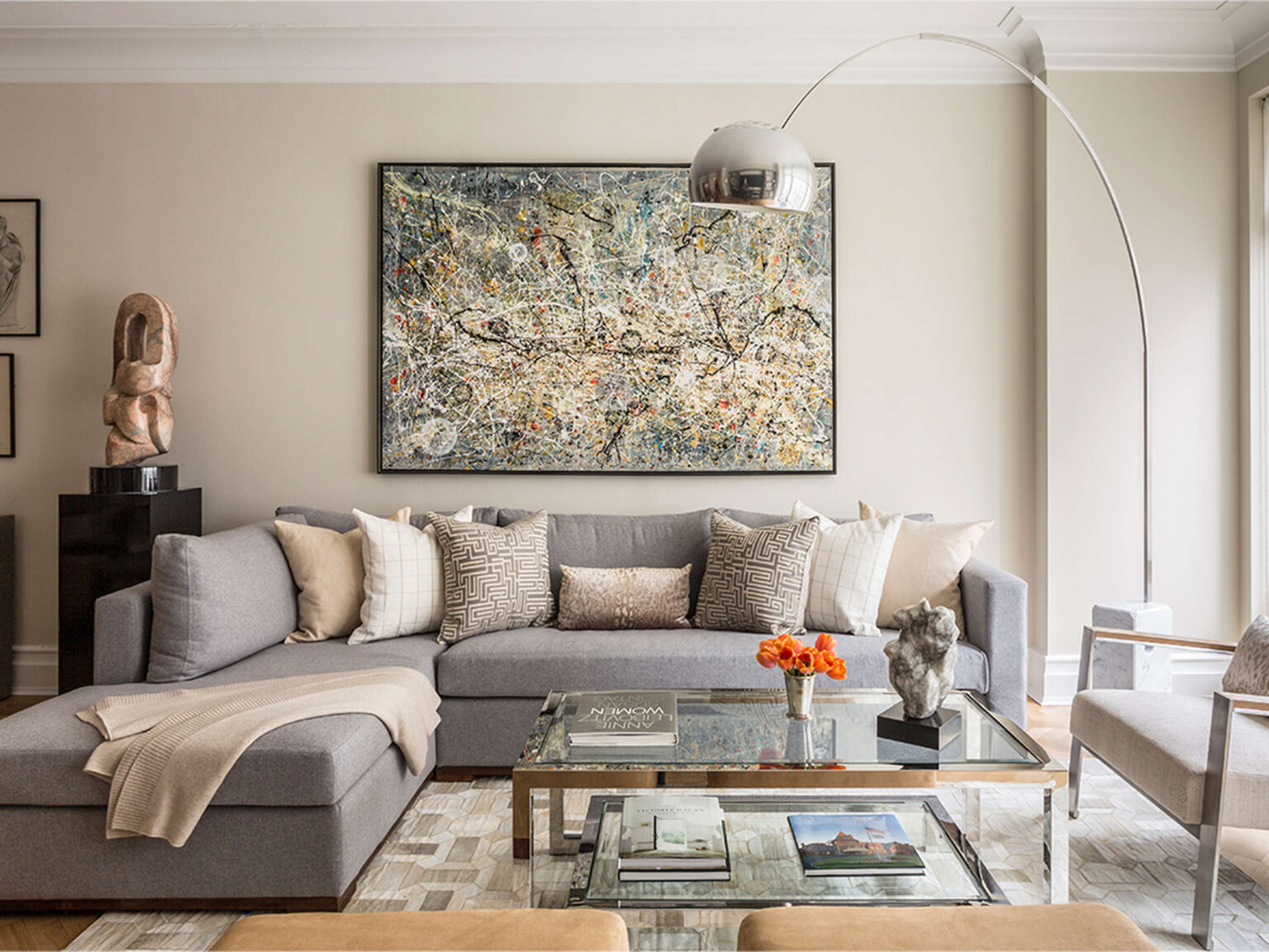 Partial retraction of Arco’s arching steel stem for height adjustment, shown beside marble-framed photograph wall.