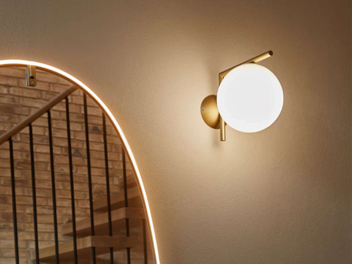 Modern ceiling or wall light, the Flos IC Lights C/W2, with a substantial milky white glass sphere seemingly floating at the end of a thin, dark metal support structure.