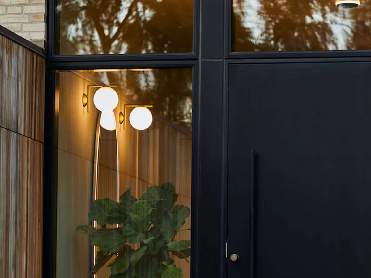 The Flos Bellhop Wall Up, a minimalist wall light designed by Barber & Osgerby, featuring a clean, rounded polycarbonate body and an integrated LED source that provides soft, diffused illumination.