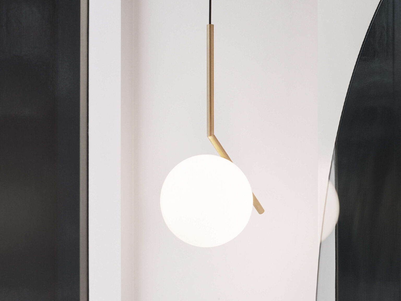 Chrome finish IC Lights S1 suspension lamp with black cable, highlighting the white glass sphere cradled by a minimalist rod.