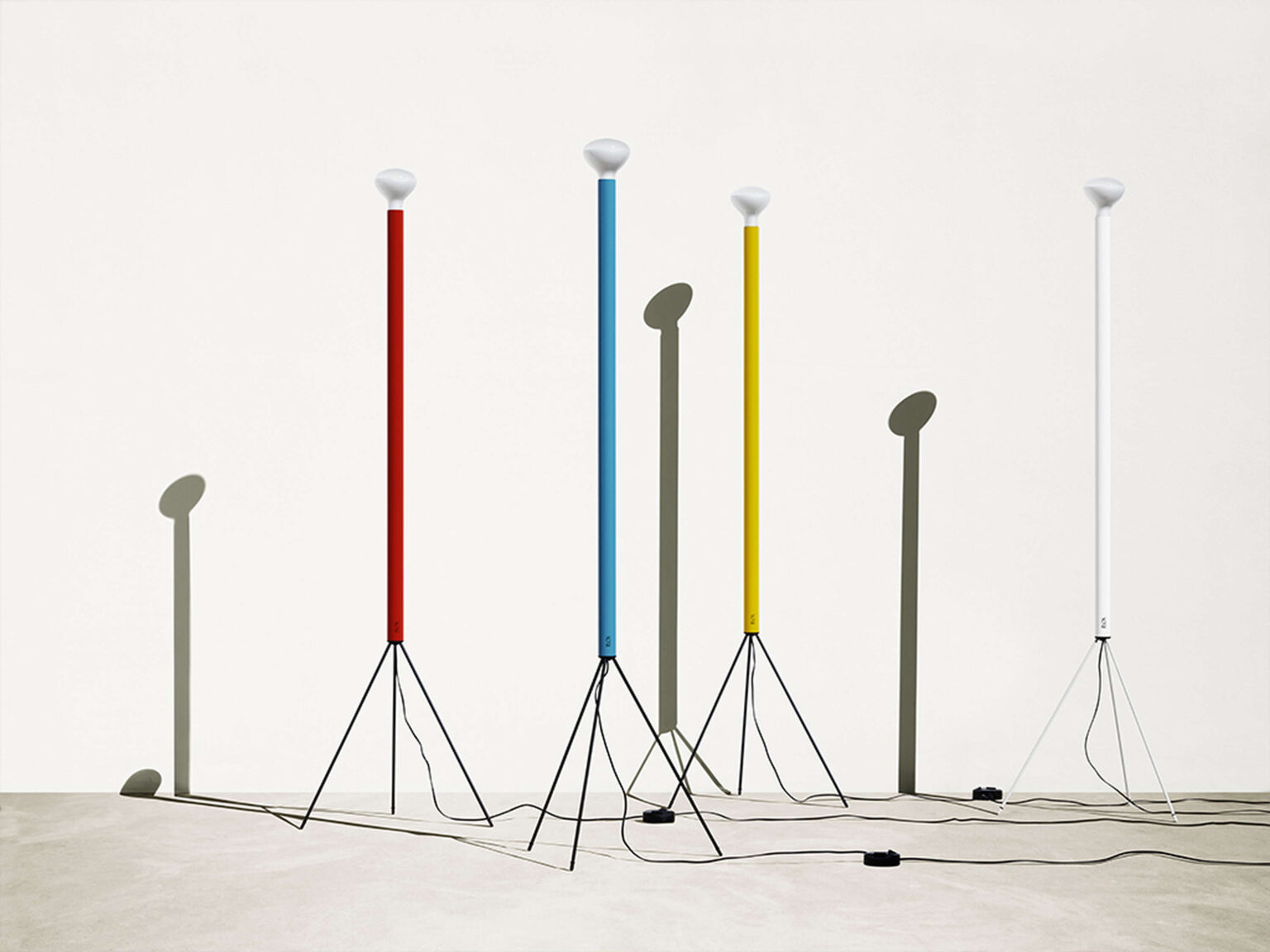 Luminator floor lamp in lite blue color, with elegant metal legs and long cable with foot dimmer switch.