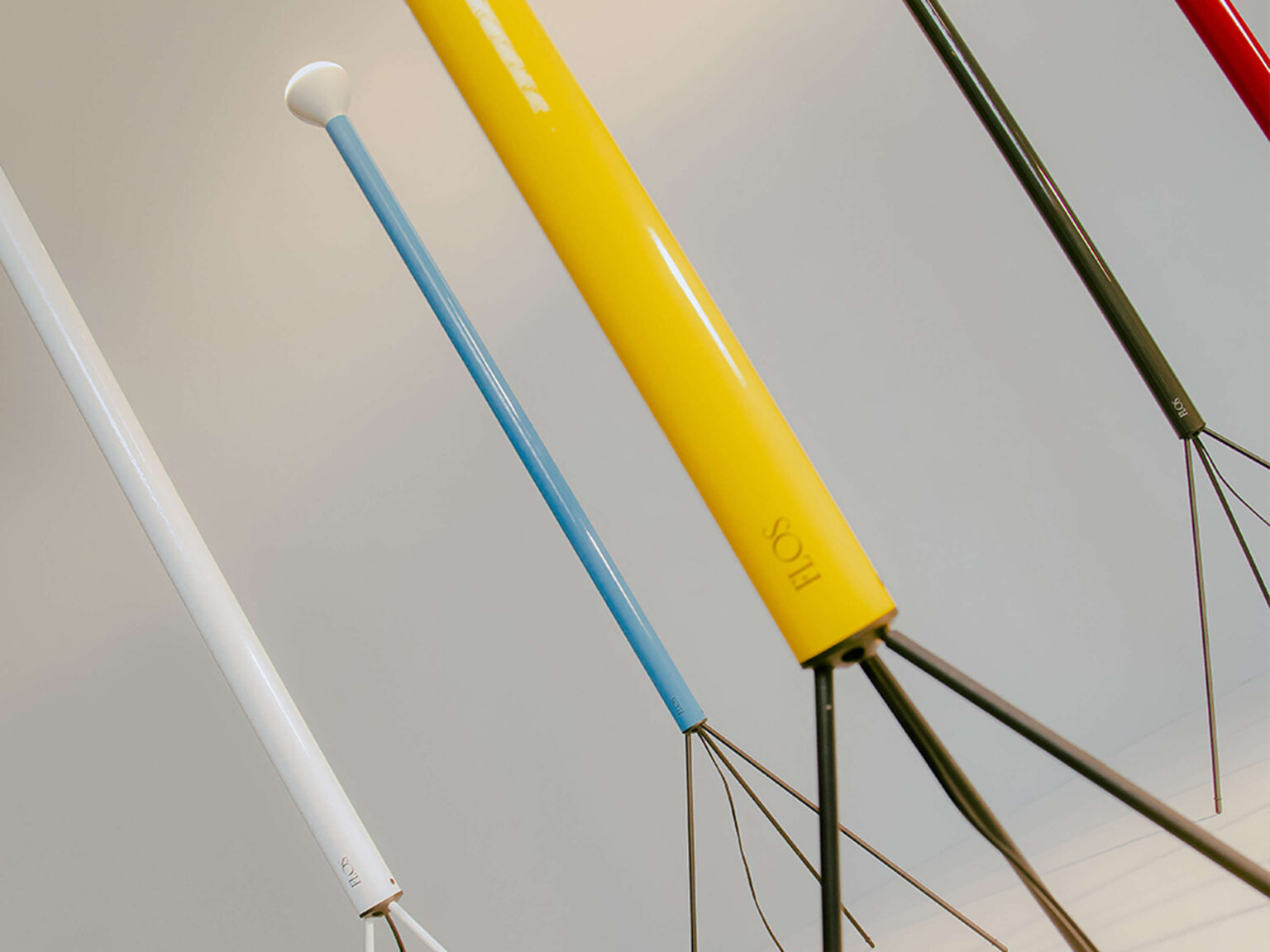 Minimalist floor uplighter: painted iron column with black cord and tripod legs, topped by an E27 reflector bulb hidden under a dome