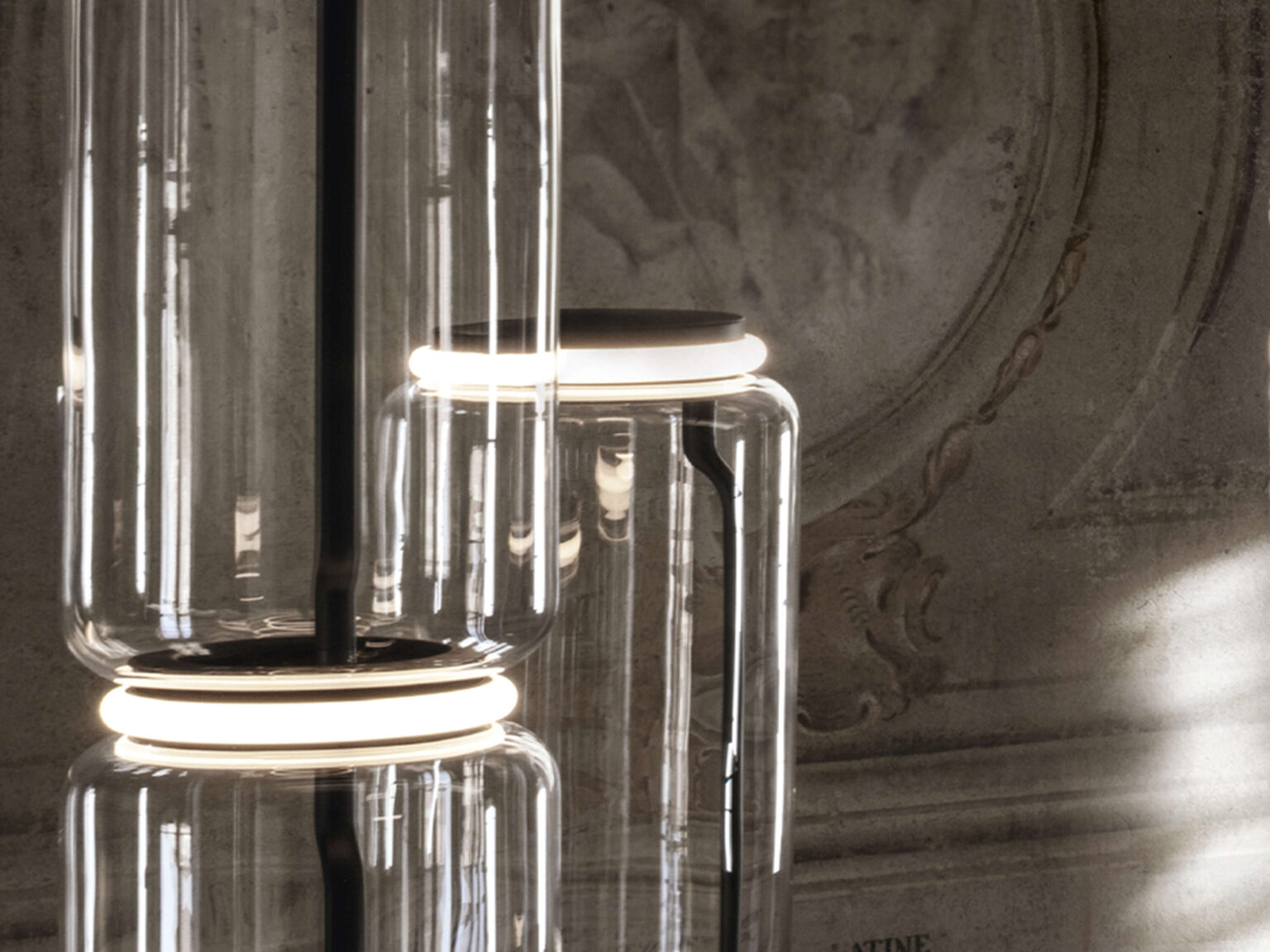 Night‑time ambience: glowing Noctambule tower with warm 2700 K LED light in a modern living space.