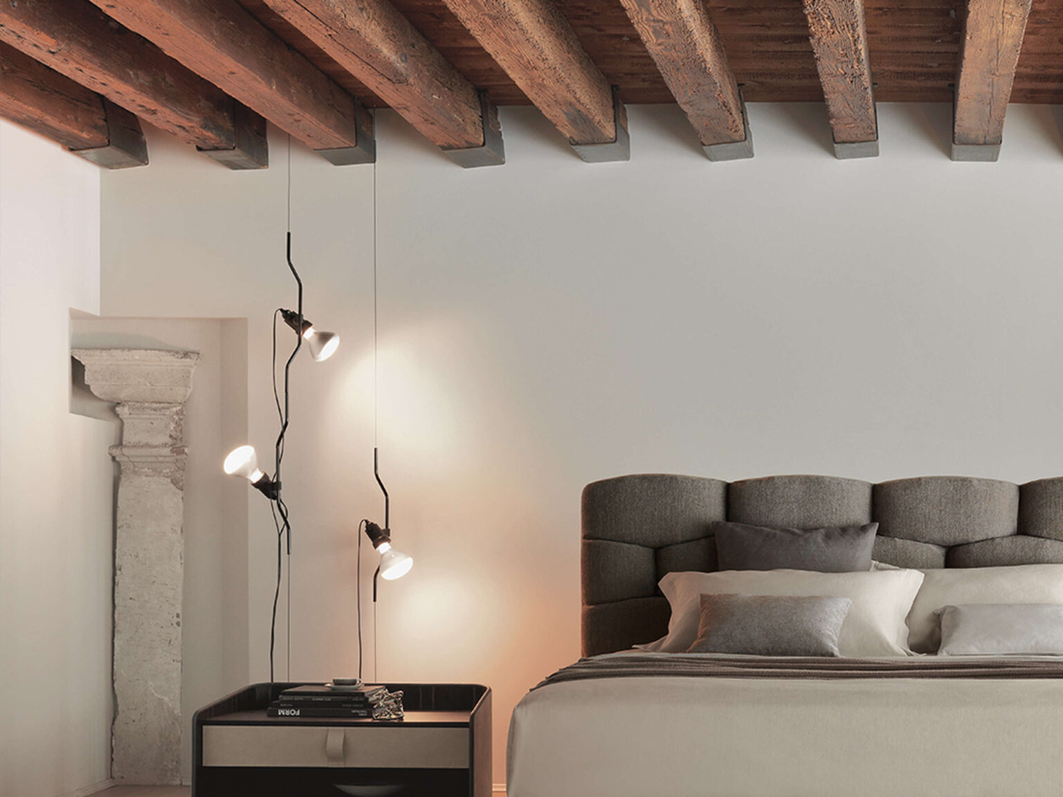 Two Parentesi suspension lamps—one in black, one in red—mounted side by side in a sleek hallway with polished floors.