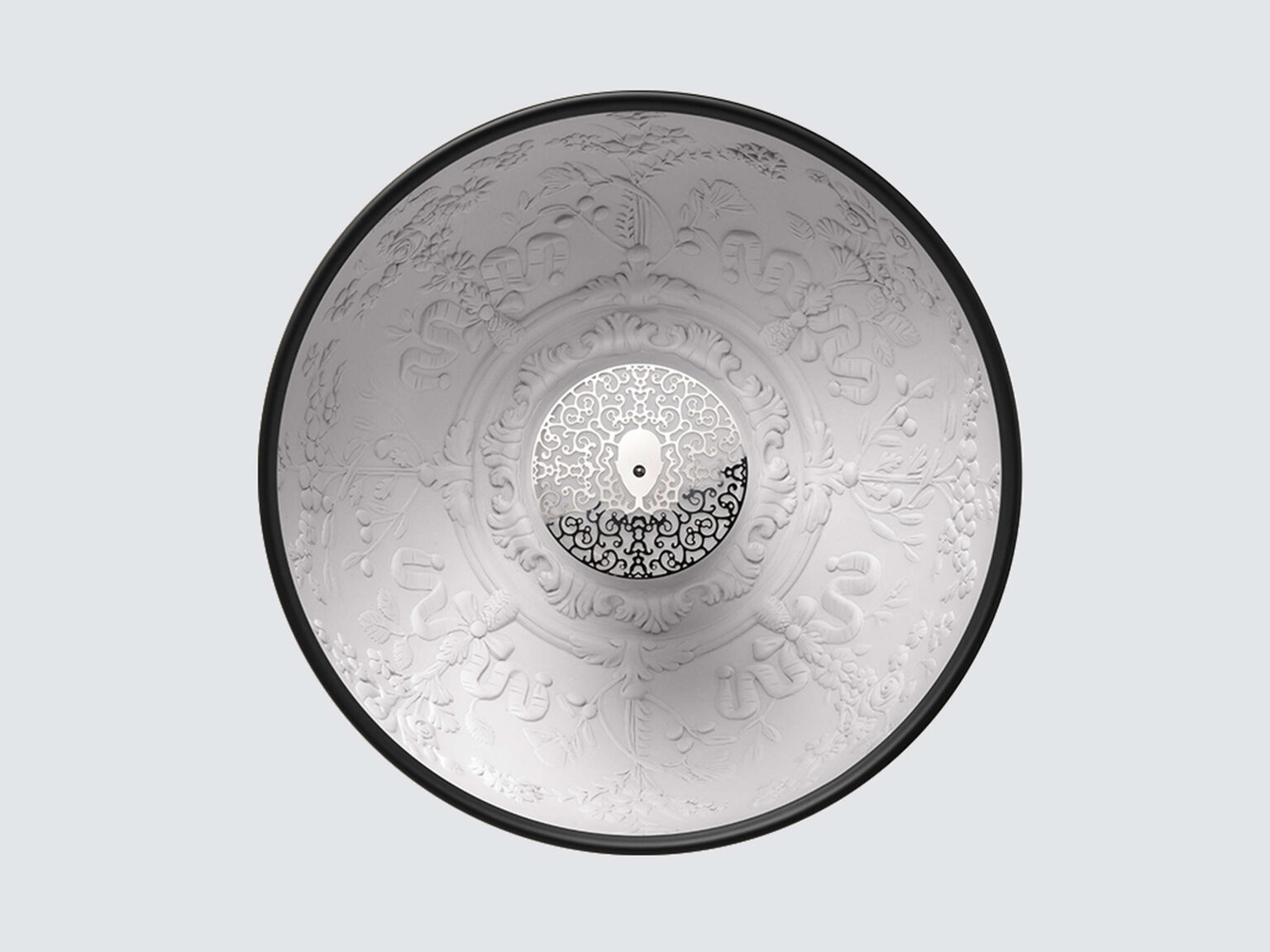 Glossy white Skygarden Small pendant showcasing intricate cast-plaster floral patterns inside the half-sphere dome, suspended above a modern workspace.